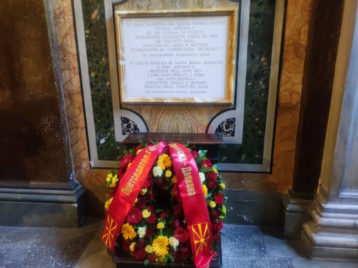 Siljanovska Davkova vendosi një kurorë lulesh para pllakës përkujtimore në gjuhën maqedonase në Bazilikën 