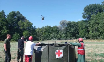 Волонтери на Црвен крст поставија мобилен резервоар за вода од каде хеликоптери црпеа вода за гаснење на големиот шумски пожар  